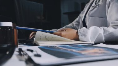 Doktor Eli 'nin hastanede elinde kalem ve kitap tutmasını kapatın.