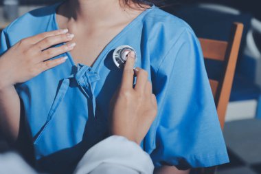 healthy concept; Doctor checking patient's heart with stethoscope at a hospital