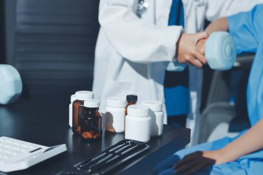 Fizyoterapist, halter egzersizinde bir kadına yardım ediyor.