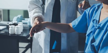 Hastane odasında hastanın dirseğini muayene eden doktor.