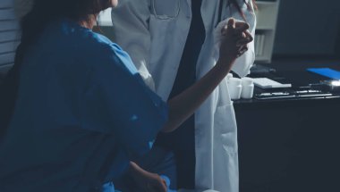 Hastane odasında hastanın dirseğini muayene eden doktor.