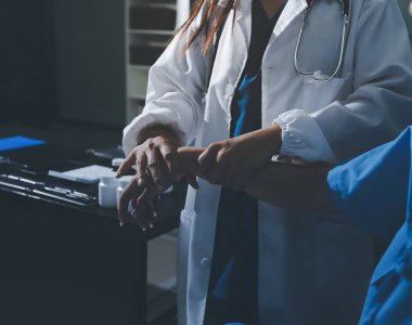 Hastane odasında hastanın dirseğini muayene eden doktor.