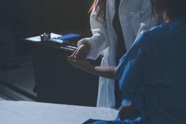 Hastane odasında hastanın dirseğini muayene eden doktor.