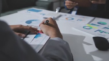 Hesap makinesi kullanan ve masa üzerinde grafik ve belgelerle muhasebe yapan işadamlarının ellerini kapat.