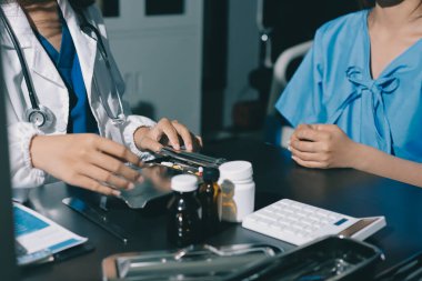 Elinde ilaç şişesi olan kadın doktor hastanın yan etkileri için ilaç kalitesini kontrol ediyor ve hasta bilgilerini hastanede kaydediyor. tıbbi ve sağlık hizmetleri kavramı