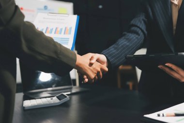 Genç iş adamları ofiste el sıkışıyor. Başarılı toplantı sona eriyor. Üç kişi. Geniş ekran panoramik