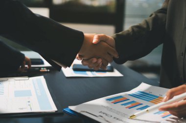 Genç iş adamları ofiste el sıkışıyor. Başarılı toplantı sona eriyor. Üç kişi. Geniş ekran panoramik