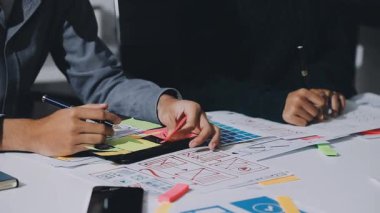 UXUI Tasarım İşbirliği. Modern çalışma alanında dijital projeyi tartışan profesyoneller.