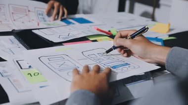 UXUI Tasarım İşbirliği. Modern çalışma alanında dijital projeyi tartışan profesyoneller.