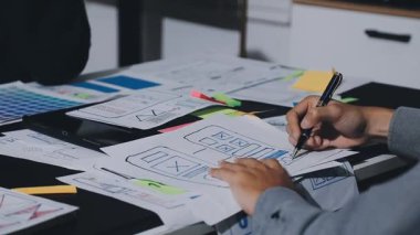 UXUI Tasarım İşbirliği. Modern çalışma alanında dijital projeyi tartışan profesyoneller.