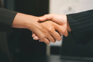 Genç iş adamları ofiste el sıkışıyor. Başarılı toplantı sona eriyor. Üç kişi. Geniş ekran panoramik