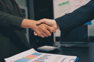 Genç iş adamları ofiste el sıkışıyor. Başarılı toplantı sona eriyor. Üç kişi. Geniş ekran panoramik