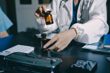 Elinde ilaç şişesi olan kadın doktor hastanın yan etkileri için ilaç kalitesini kontrol ediyor ve hasta bilgilerini hastanede kaydediyor. tıbbi ve sağlık hizmetleri kavramı