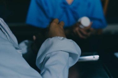 Elinde ilaç şişesi olan kadın doktor hastanın yan etkileri için ilaç kalitesini kontrol ediyor ve hasta bilgilerini hastanede kaydediyor. tıbbi ve sağlık hizmetleri kavramı