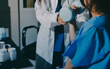 Fizyoterapist, halter egzersizinde bir kadına yardım ediyor.