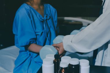 Fizyoterapist, halter egzersizinde bir kadına yardım ediyor.