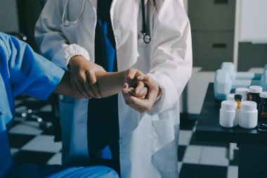 Hastane odasında hastanın dirseğini muayene eden doktor.