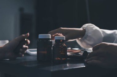 Elinde ilaç şişesi olan kadın doktor hastanın yan etkileri için ilaç kalitesini kontrol ediyor ve hasta bilgilerini hastanede kaydediyor. tıbbi ve sağlık hizmetleri kavramı