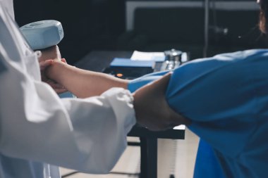 Fizyoterapist, halter egzersizinde bir kadına yardım ediyor.