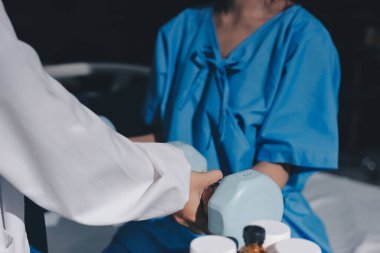 Fizyoterapist, halter egzersizinde bir kadına yardım ediyor.