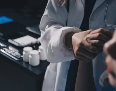 Hastane odasında hastanın dirseğini muayene eden doktor.