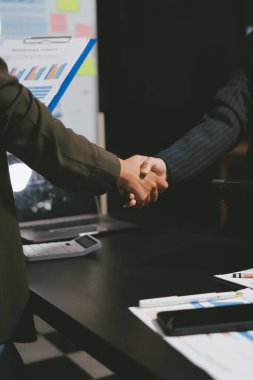 Genç iş adamları ofiste el sıkışıyor. Başarılı toplantı sona eriyor. Üç kişi. Geniş ekran panoramik