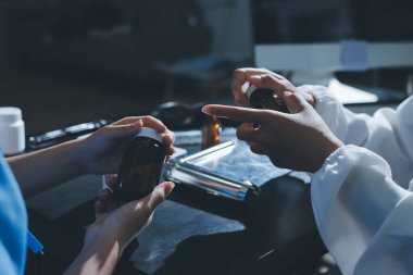 Elinde ilaç şişesi olan kadın doktor hastanın yan etkileri için ilaç kalitesini kontrol ediyor ve hasta bilgilerini hastanede kaydediyor. tıbbi ve sağlık hizmetleri kavramı