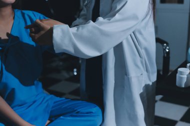 Hastane odasında hastanın dirseğini muayene eden doktor.