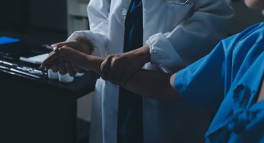 Hastane odasında hastanın dirseğini muayene eden doktor.