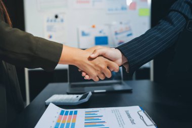 Genç iş adamları ofiste el sıkışıyor. Başarılı toplantı sona eriyor. Üç kişi. Geniş ekran panoramik