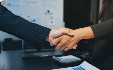 Genç iş adamları ofiste el sıkışıyor. Başarılı toplantı sona eriyor. Üç kişi. Geniş ekran panoramik