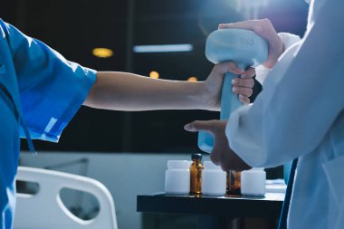 Fizyoterapist, halter egzersizinde bir kadına yardım ediyor.