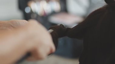 Usta kadın kuaför, kuaförde yıkandıktan sonra kızın saçını saç kurutma makinesiyle kurutur..