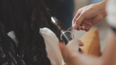 Tahta bir sandalyede alyans tutan bir kadının yakın çekimi.