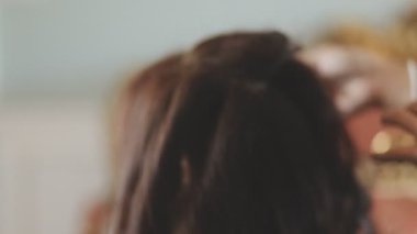 Usta kadın kuaför, kuaförde yıkandıktan sonra kızın saçını saç kurutma makinesiyle kurutur..