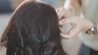 Usta kadın kuaför, kuaförde yıkandıktan sonra kızın saçını saç kurutma makinesiyle kurutur..