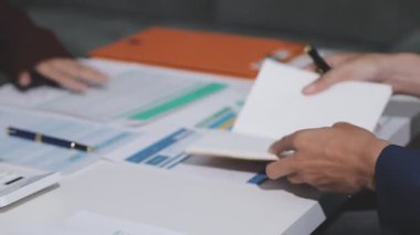 Ofiste çalışan denetçi ve muhasebeci ekibi mali verileri ve muhasebe kayıtlarını hesap makinesiyle analiz ediyor. Muhasebe şirketi kârlı nakit akışı için finansman ve vergilendirme planlaması sağlıyor