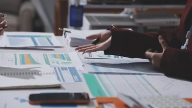 Ofiste çalışan denetçi ve muhasebeci ekibi mali verileri ve muhasebe kayıtlarını hesap makinesiyle analiz ediyor. Muhasebe şirketi kârlı nakit akışı için finansman ve vergilendirme planlaması sağlıyor