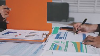 Ofiste çalışan denetçi ve muhasebeci ekibi mali verileri ve muhasebe kayıtlarını hesap makinesiyle analiz ediyor. Muhasebe şirketi kârlı nakit akışı için finansman ve vergilendirme planlaması sağlıyor