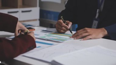 Ofiste çalışan denetçi ve muhasebeci ekibi mali verileri ve muhasebe kayıtlarını hesap makinesiyle analiz ediyor. Muhasebe şirketi kârlı nakit akışı için finansman ve vergilendirme planlaması sağlıyor. İçgörü