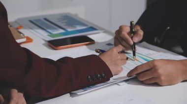 Ofiste çalışan denetçi ve muhasebeci ekibi mali verileri ve muhasebe kayıtlarını hesap makinesiyle analiz ediyor. Muhasebe şirketi kârlı nakit akışı için finansman ve vergilendirme planlaması sağlıyor. İçgörü