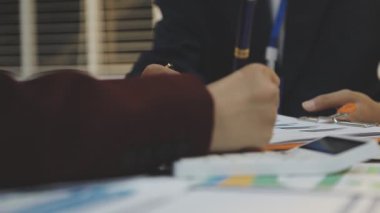 Ofiste çalışan denetçi ve muhasebeci ekibi mali verileri ve muhasebe kayıtlarını hesap makinesiyle analiz ediyor. Muhasebe şirketi kârlı nakit akışı için finansman ve vergilendirme planlaması sağlıyor. İçgörü