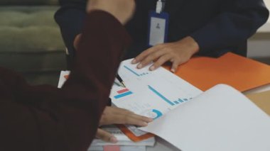 Ofiste çalışan denetçi ve muhasebeci ekibi mali verileri ve muhasebe kayıtlarını hesap makinesiyle analiz ediyor. Muhasebe şirketi kârlı nakit akışı için finansman ve vergilendirme planlaması sağlıyor. İçgörü