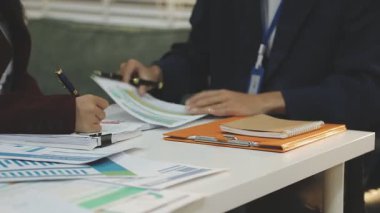 Ofiste çalışan denetçi ve muhasebeci ekibi mali verileri ve muhasebe kayıtlarını hesap makinesiyle analiz ediyor. Muhasebe şirketi kârlı nakit akışı için finansman ve vergilendirme planlaması sağlıyor. İçgörü