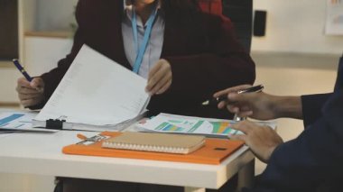 Ofiste çalışan denetçi ve muhasebeci ekibi mali verileri ve muhasebe kayıtlarını hesap makinesiyle analiz ediyor. Muhasebe şirketi kârlı nakit akışı için finansman ve vergilendirme planlaması sağlıyor. İçgörü