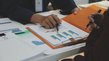 Ofiste çalışan denetçi ve muhasebeci ekibi mali verileri ve muhasebe kayıtlarını hesap makinesiyle analiz ediyor. Muhasebe şirketi kârlı nakit akışı için finansman ve vergilendirme planlaması sağlıyor. İçgörü