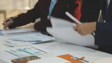 Ofiste çalışan denetçi ve muhasebeci ekibi mali verileri ve muhasebe kayıtlarını hesap makinesiyle analiz ediyor. Muhasebe şirketi kârlı nakit akışı için finansman ve vergilendirme planlaması sağlıyor. İçgörü