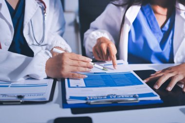 Tıbbi ekip toplantısı, brifing sırasında not alan doktorlar.