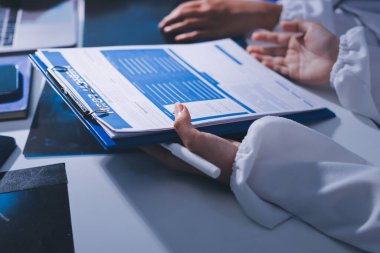 Tıbbi ekip toplantısı, brifing sırasında not alan doktorlar.