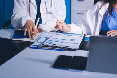 Tıbbi ekip toplantısı, brifing sırasında not alan doktorlar.